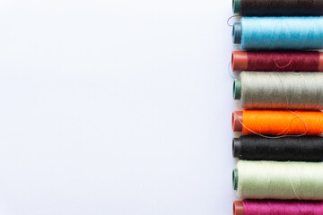 Top view of colorful threads on white background with various layouts.