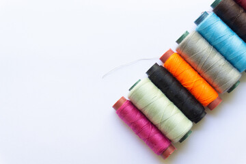 Top view of colorful threads on white background with various layouts.