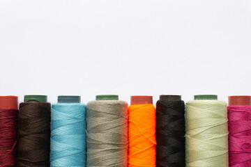 Top view of colorful threads on white background with various layouts.