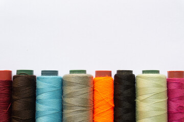 Top view of colorful threads on white background with various layouts.