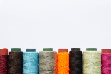 Top view of colorful threads on white background with various layouts.