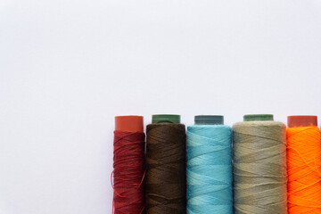 Top view of colorful threads on white background with various layouts.