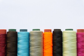 Top view of colorful threads on white background with various layouts.