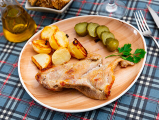 Delicious pork steak served with potatoes and pickles. Festive dinner