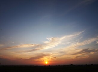 photo of the sky in a bright afternoon, and the sun looks yellow about to set and beautiful white clouds