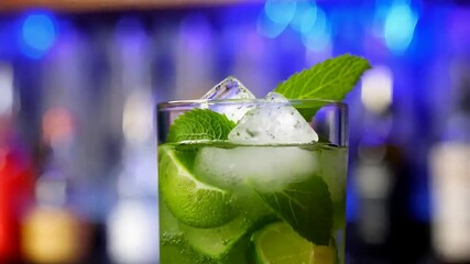 Mojito cocktail sparkles with ice cubes and fresh mint leaves