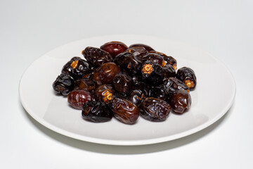 Dried dates on white background. Premium quality date fruit isolated on a plate. Date fruit with white background.