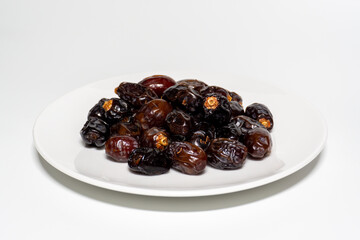Dried dates on white background. Premium quality date fruit isolated on a plate. Date fruit with white background.