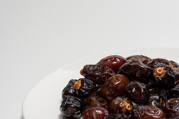 Dried dates on white background. Premium quality date fruit isolated on a plate. Date fruit with white background.