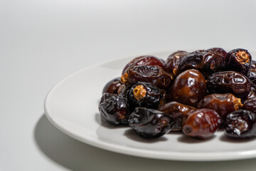 Dried dates on white background. Premium quality date fruit isolated on a plate. Date fruit with white background.