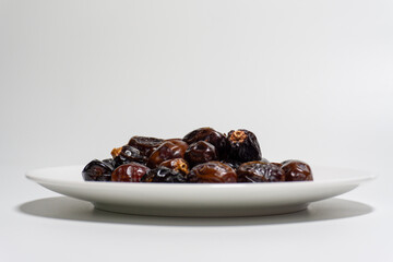 Dried dates on white background. Premium quality date fruit isolated on a plate. Date fruit with white background.
