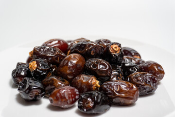 Dried dates on white background. Premium quality date fruit isolated on a plate. Date fruit with white background.