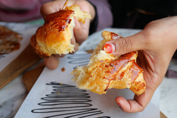 A Freshly Baked Croissant Deliciously Being Shared Among Friends and Family Members