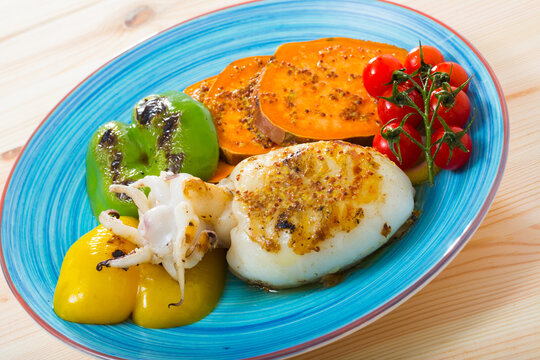 Grilled sepia with Bulgarian pepper and boiled Batat served on plate