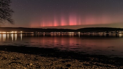 The stunning Northern Lights over a fjord in Norway, reflecting in the water below.