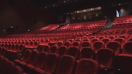 Close-up shot of red chairs in empty movie theater