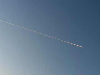 朝日に照らされた飛行機雲