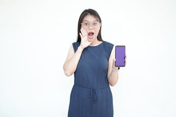 Beautiful Asian woman holds a smartphone with a blank screen, shouting with one hand over her mouth