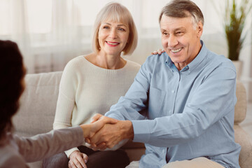 Obraz premium Nice To Meet You. Young female therapist meeting elderly couple for a counselling session, greeting with handshake