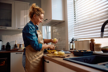 Smiling woman preparing food for Thanksgiving dinner in kitchen.