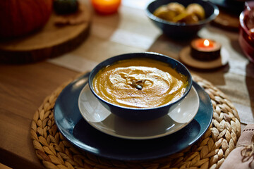 Thanksgiving pumpkin soup on dining table.