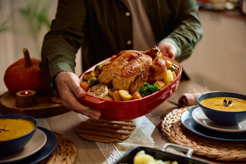 Close up of man serving Thanksgiving turkey at dining table.