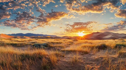A picturesque sunset over a field of sand dunes with warm, glowing colors