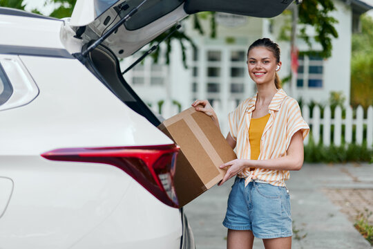 delivery, happiness, package, woman, car, outdoors, smiling, summer, casual, lifestyle, cheerful, brown box, loading, vehicle, environment, content, excitement, friendly, youthful, parked car