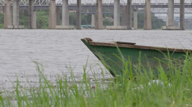 Side shot of an old rustic boat on lake ona rainy day