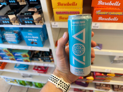 Holding a can of ZOA energy drink.