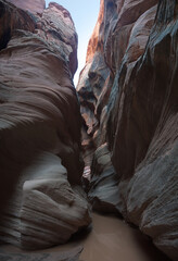 Hiking in Buckskin Gulch by the Flooded canyon bottom after the rain 