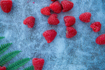 Sweet red raspberries. Juicy raspberries on the table with palm tree leaf