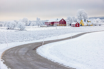 Snowy winding country road to a farm in the countryside in the winter