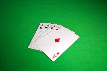 close up of four aces poker card on green table for background