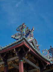 Ancient Chinese-style roof details in George town, Penang, stand out against blue sky.