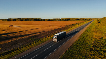 Trucks are driving along the highway at a beautiful dawn