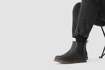 Man in black winter boots on white background