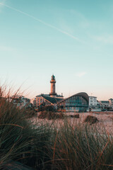 Teepott in Warnemünde mit Leuchtturm im Morgenlicht