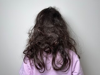 Wild curly black tangled hair of a little girl view from the back of the head – Kids with Curly Hair Maintenance and Grooming Abstract Background
