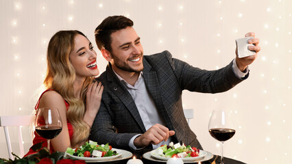 Romantic Selfie. Loving Young Couple Taking Self-Portrait While Dining In Restaurant, Celebrating Valentine's Day Together, Free Space