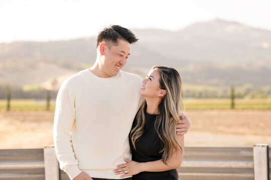 Couple smiling at each other in front of beautiful country
