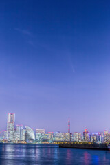 Fototapeta premium 横浜港からみなとみらいのビル群に沈むアトラス彗星