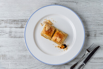 Traditional Turkish dessert walnut baklava on a white porcelain plate