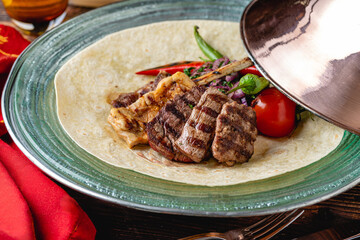 Mixed Turkish grill consisting of adana kebab, grilled chicken and lamb tandoori on wooden table