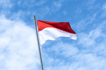 Indonesian Flag, Red and White, with blue sky background.