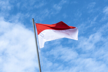 Indonesian Flag, Red and White, with blue sky background.