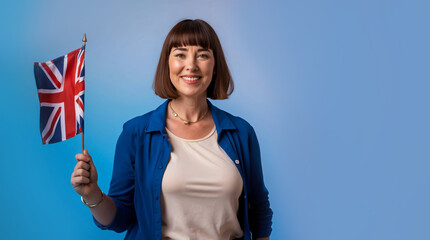 Learning English language. Woman is holding United Kingdom flag on blue background with copy space. Teaching English for foreigners