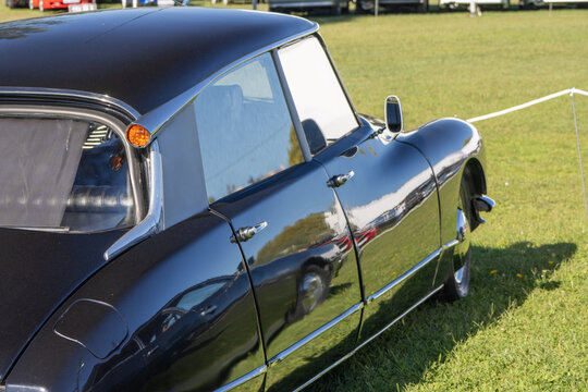 Black citroen ds parked on grass reflecting the sky