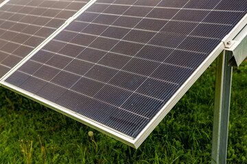 Solar panel on green grass background. Alternative energy concept. Top view.