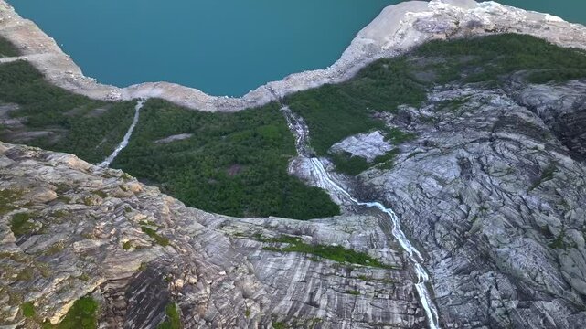 Waterfall ob the Slope of Ringedalsvatnet Lake where Troll Tongue or Trolltunga located. Aerial Drone Shot over a Fjord